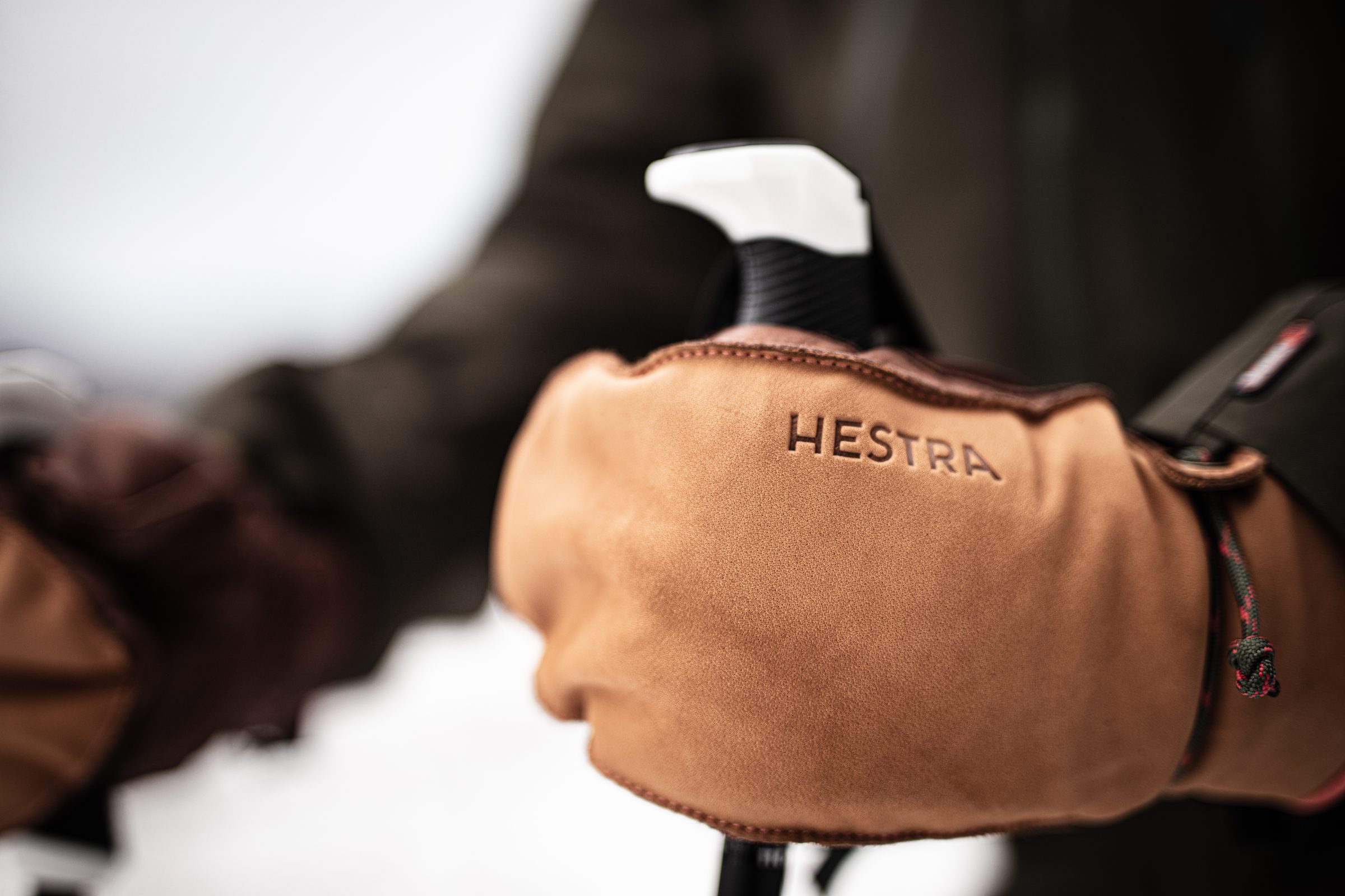 Leren Hestra-handschoen aan een skistok