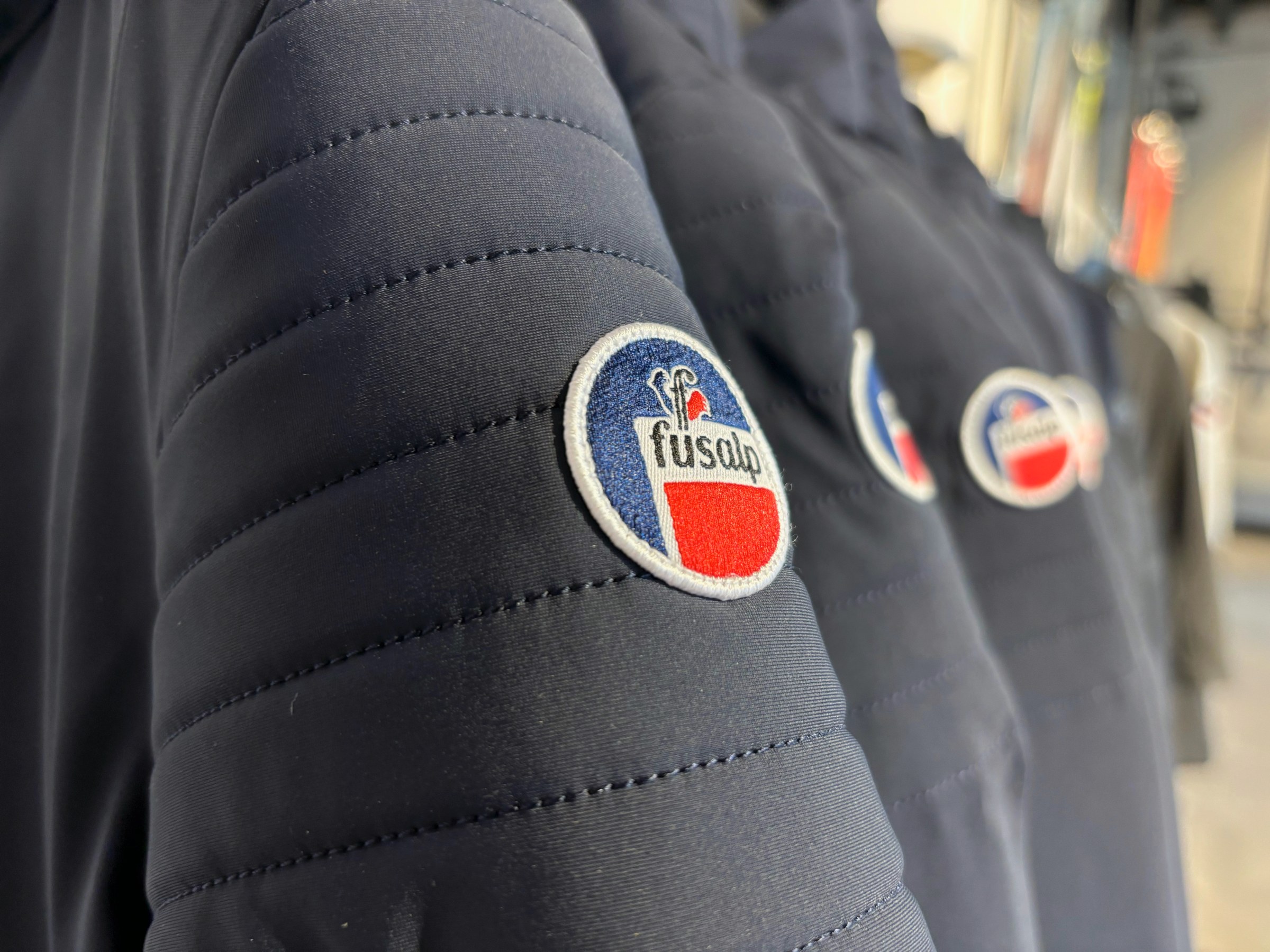 Fusalp-badge op de mouw van een donkerblauwe jas